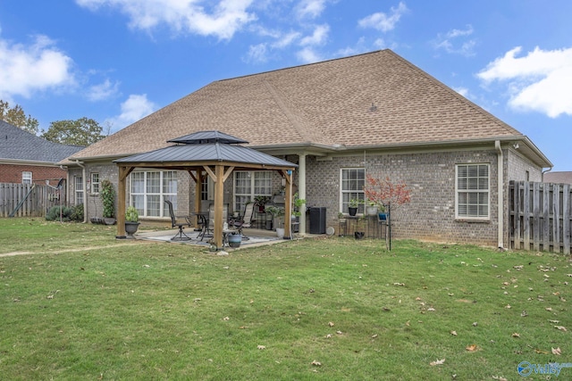 rear view of property featuring a gazebo, a patio area, and a lawn