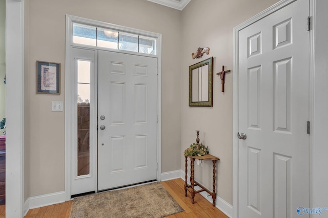 entrance foyer with ornamental molding and light wood-type flooring