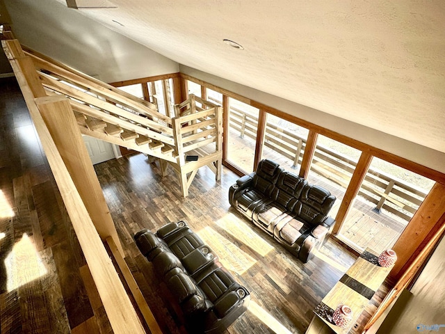 unfurnished living room with lofted ceiling, wood-type flooring, and a textured ceiling