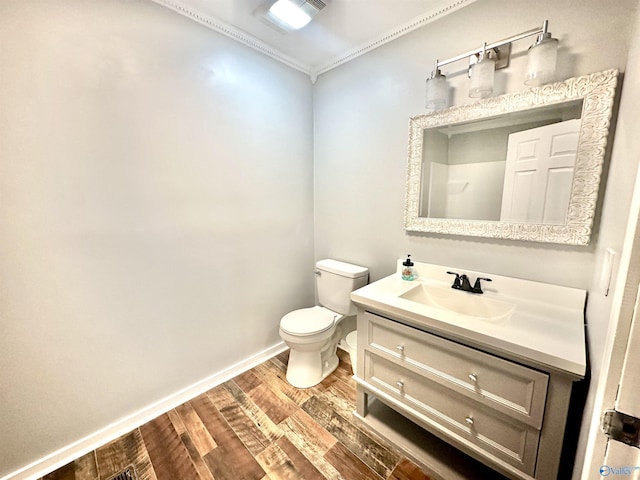 bathroom with hardwood / wood-style floors, vanity, toilet, and crown molding