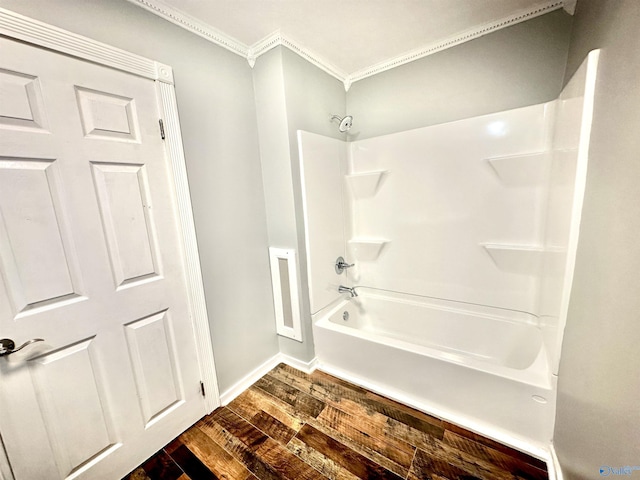 bathroom featuring ornamental molding, wood-type flooring, and tub / shower combination