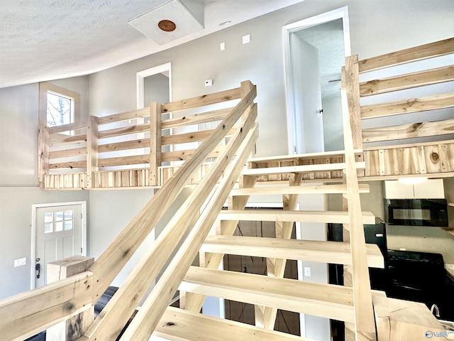 staircase with a textured ceiling