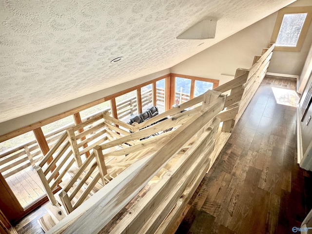 interior space featuring a textured ceiling, lofted ceiling, and dark wood-type flooring