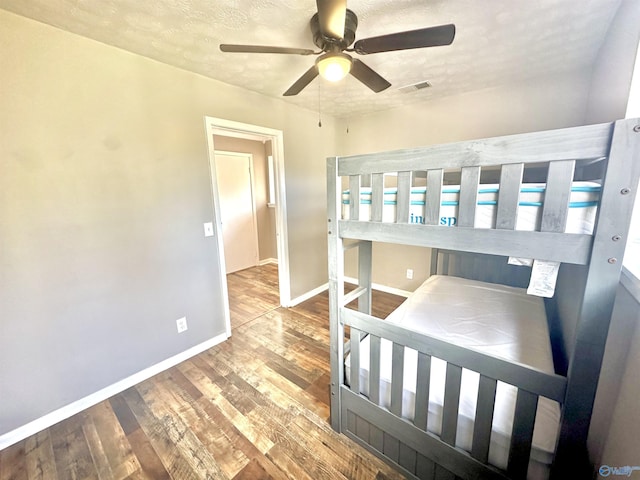 bedroom featuring ceiling fan, a textured ceiling, and hardwood / wood-style flooring