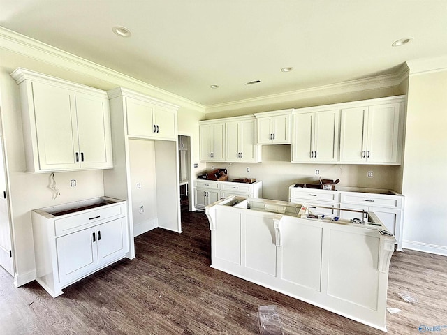 1005 Newbury Cv SW, Decatur, AL 35603 - kitchen featuring crown molding, baseboards, a center island, dark wood finished floors, and white cabinetry