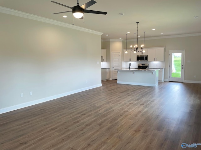 unfurnished living room with ceiling fan with notable chandelier, dark wood-type flooring, sink, and crown molding