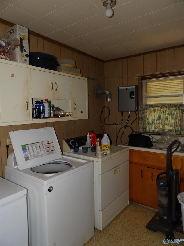 laundry room featuring wooden walls and washing machine and clothes dryer