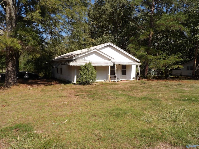 view of side of home with a lawn and covered porch