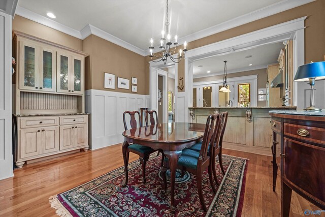 9 Beck St NW, Huntsville, AL 35806 - dining area with wainscoting, an inviting chandelier, ornamental molding, and light wood-style flooring