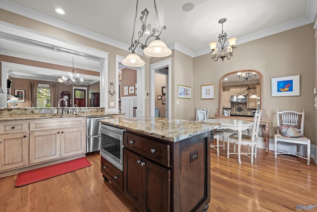 9 Beck St NW, Huntsville, AL 35806 - kitchen featuring light wood-type flooring, a sink, an inviting chandelier, and stainless steel microwave