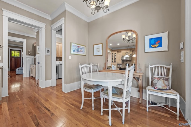 9 Beck St NW, Huntsville, AL 35806 - dining space featuring a chandelier, light wood-style flooring, baseboards, and ornamental molding