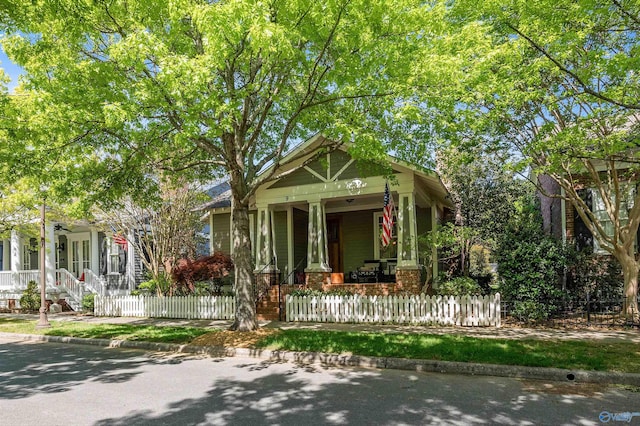 9 Beck St NW, Huntsville, AL 35806 - view of front facade featuring brick siding, a fenced front yard, and covered porch