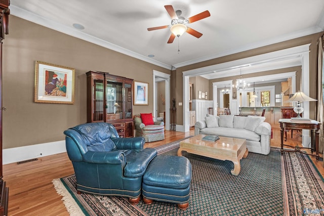 9 Beck St NW, Huntsville, AL 35806 - living area featuring crown molding, wood finished floors, visible vents, and ceiling fan with notable chandelier