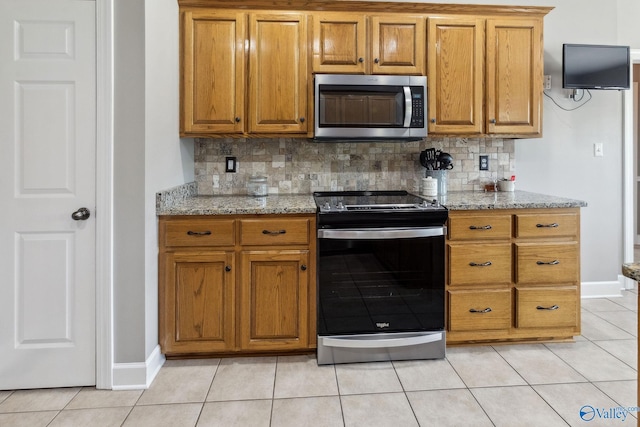 2801 Mountain View Dr, Southside, AL 35907 - kitchen featuring electric range, stainless steel microwave, tasteful backsplash, and brown cabinets