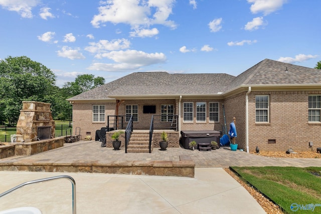 2801 Mountain View Dr, Southside, AL 35907 - back of house with a hot tub, a patio, an outdoor stone fireplace, and brick siding