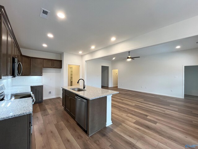 kitchen with stainless steel appliances, dark wood-type flooring, a sink, visible vents, and dark brown cabinets