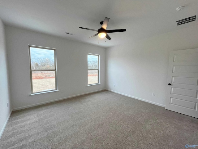 spare room featuring a ceiling fan, carpet, visible vents, and baseboards