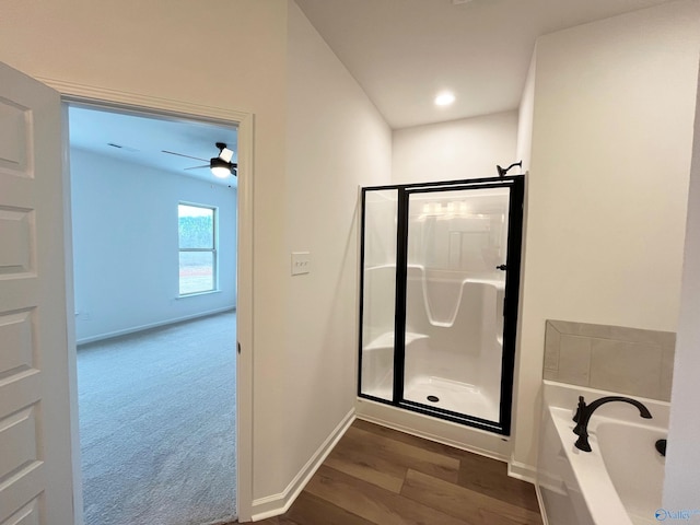 full bathroom featuring wood finished floors, a shower stall, a bath, and baseboards