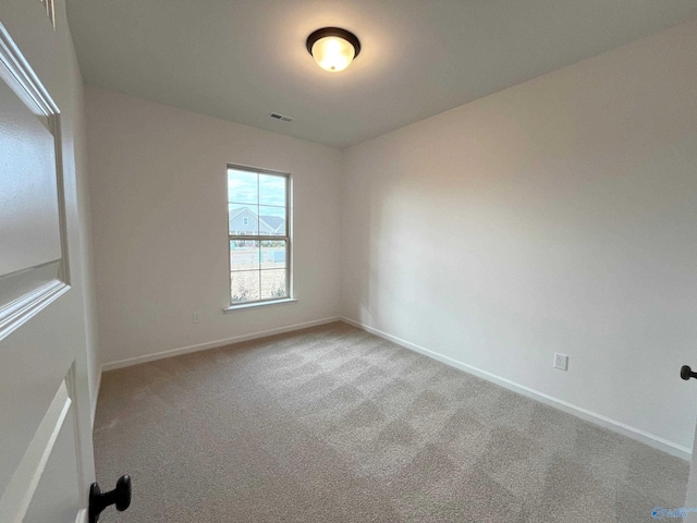 spare room with carpet floors, baseboards, and visible vents