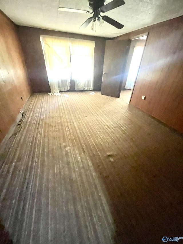 unfurnished room with ceiling fan and wood-type flooring