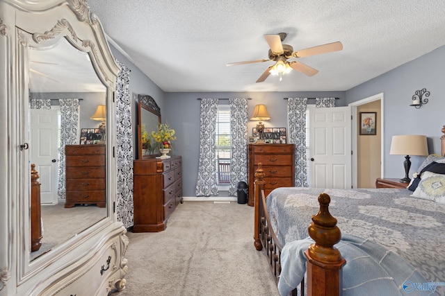 carpeted bedroom featuring ceiling fan and a textured ceiling