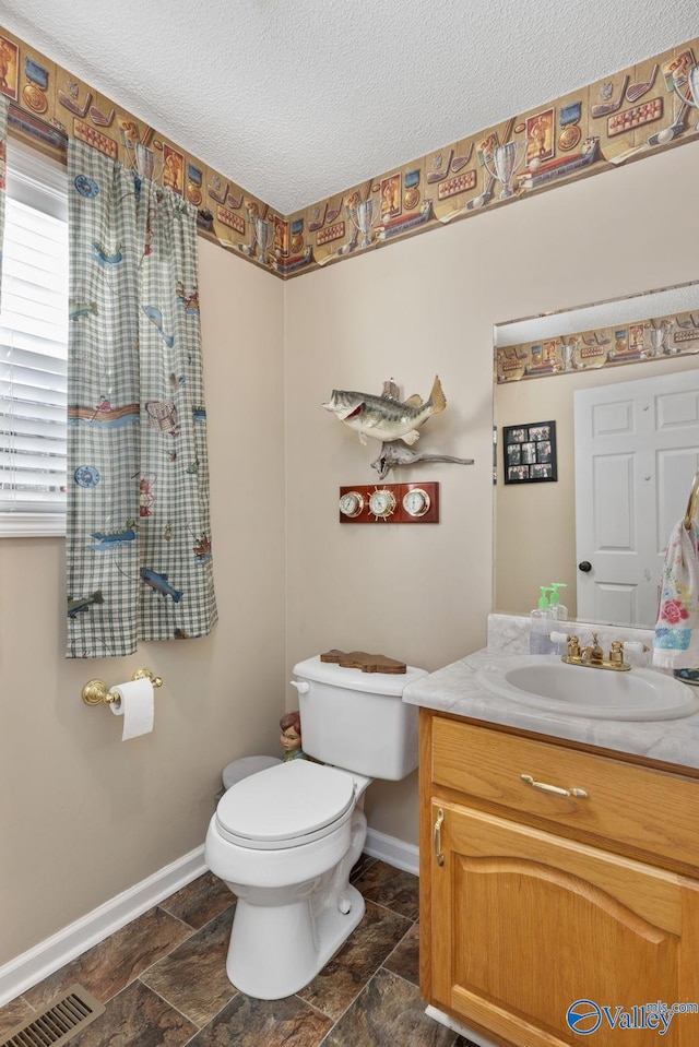 bathroom with vanity, a textured ceiling, and toilet