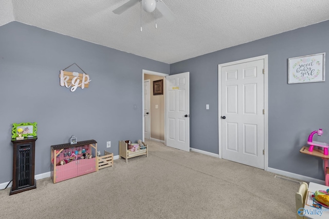 recreation room featuring ceiling fan, light colored carpet, lofted ceiling, and a textured ceiling