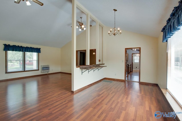 unfurnished living room with high vaulted ceiling, heating unit, dark hardwood / wood-style floors, and ceiling fan with notable chandelier