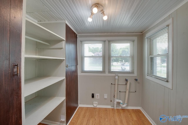 washroom with wood walls, light hardwood / wood-style floors, wooden ceiling, hookup for a washing machine, and hookup for a gas dryer