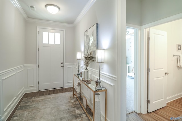 foyer with hardwood / wood-style floors and ornamental molding