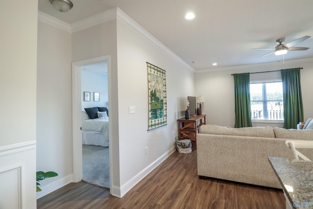 living room with crown molding, ceiling fan, and dark wood-type flooring