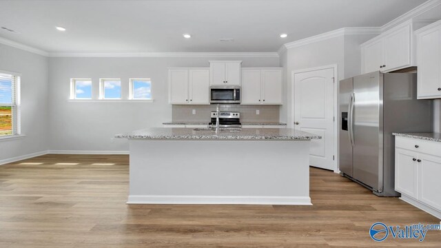 kitchen with white cabinets, stainless steel appliances, and a kitchen island with sink