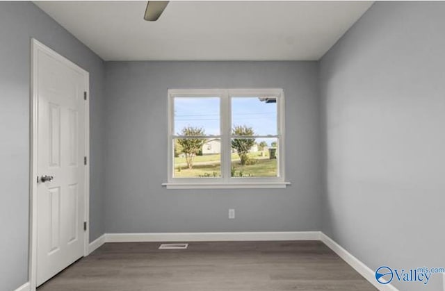 empty room featuring baseboards and wood finished floors