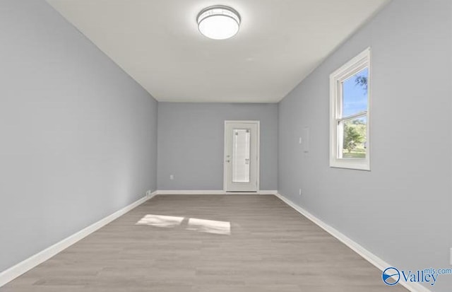additional living space with baseboards and wood finished floors