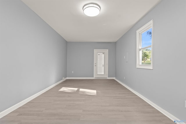 empty room with baseboards and light wood finished floors
