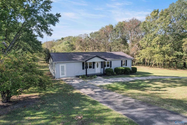 single story home with a view of trees, a front yard, metal roof, and aphalt driveway