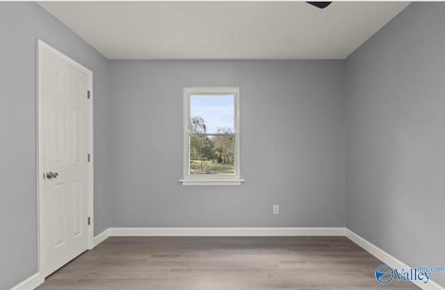 unfurnished room featuring baseboards and wood finished floors