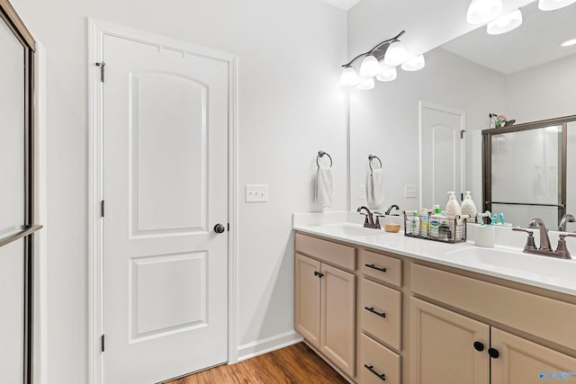 bathroom featuring hardwood / wood-style floors, a shower with door, and vanity