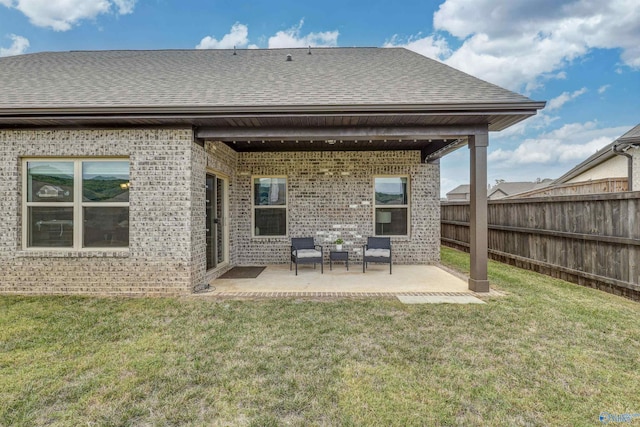 back of property with a patio area and a yard