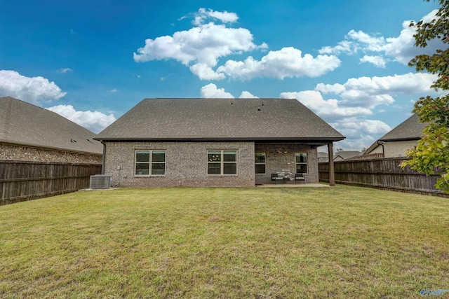 rear view of house with a patio area, central air condition unit, and a yard