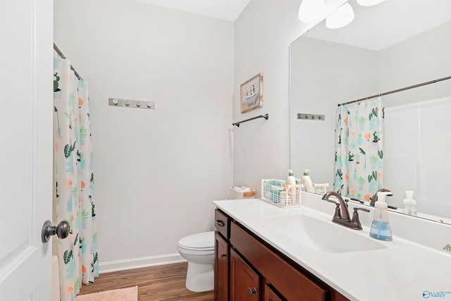 bathroom featuring hardwood / wood-style floors, curtained shower, vanity, and toilet