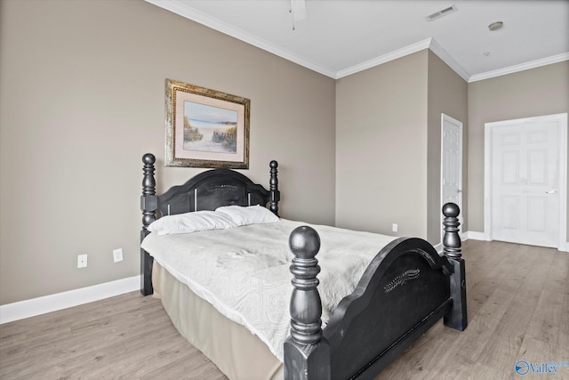 bedroom featuring visible vents, baseboards, crown molding, and wood finished floors