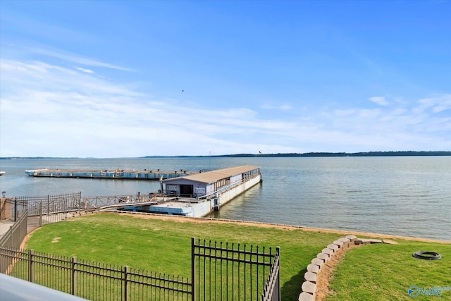 dock area featuring a yard, a water view, and fence