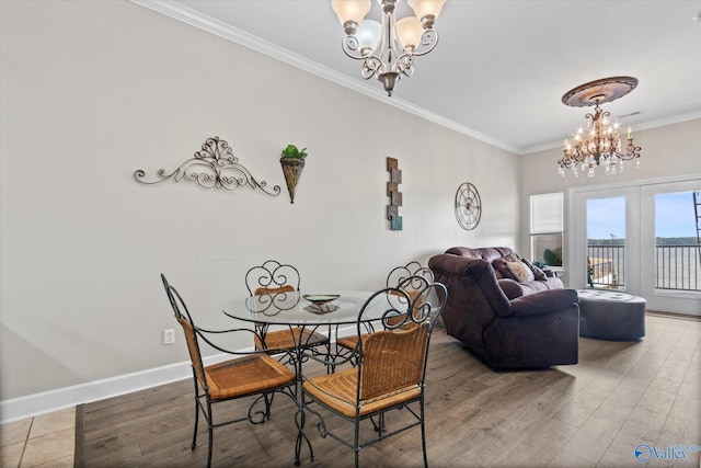 dining space with crown molding, baseboards, wood finished floors, and a chandelier