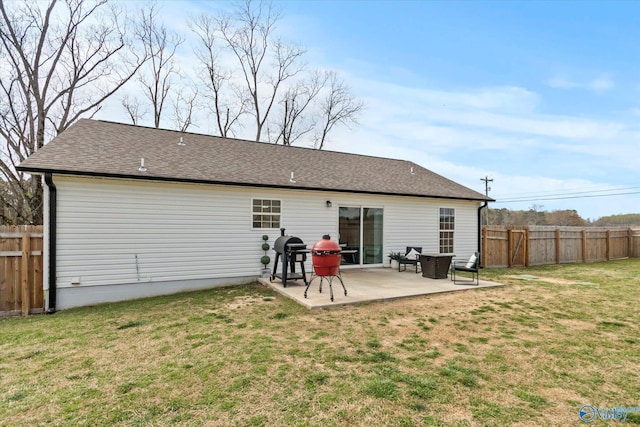 back of house with fence, a shingled roof, a patio area, and a lawn