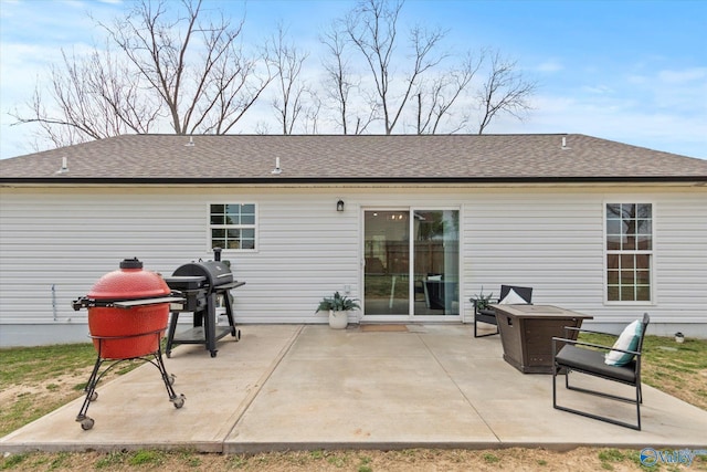 rear view of property with roof with shingles and a patio