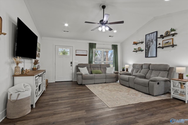 living room featuring vaulted ceiling, ornamental molding, dark wood-type flooring, ceiling fan, and visible vents