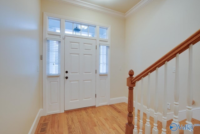 foyer featuring a healthy amount of sunlight, ornamental molding, and light hardwood / wood-style flooring