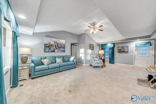 carpeted living room featuring ceiling fan, a textured ceiling, and lofted ceiling