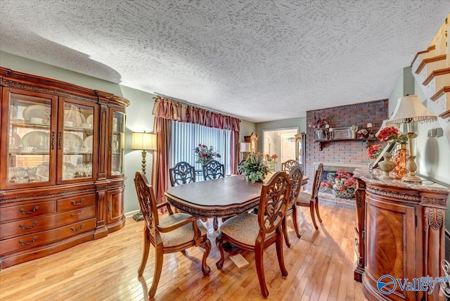 dining space with light hardwood / wood-style floors and a textured ceiling